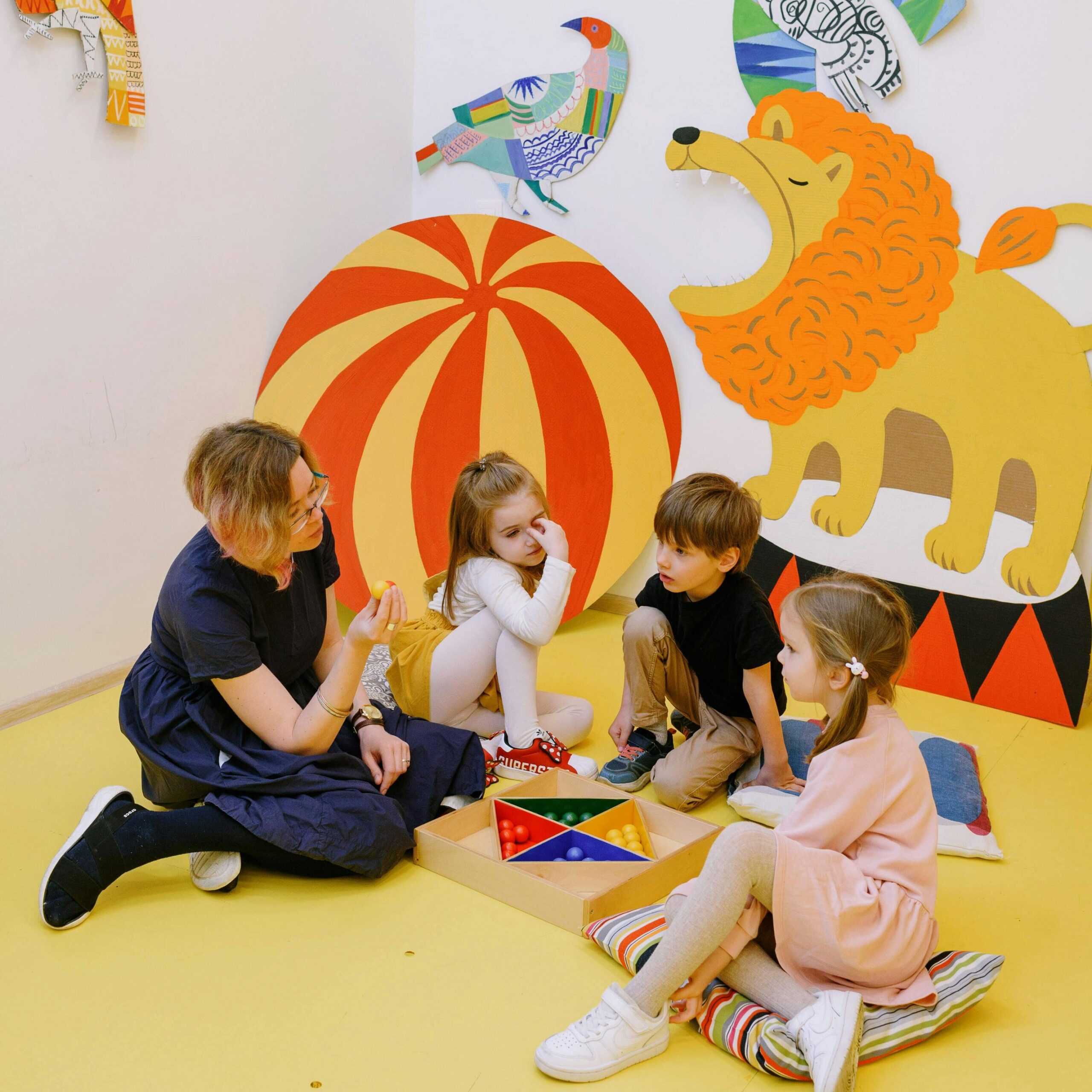 Children and teacher engaging in creative play in a colorful preschool classroom.